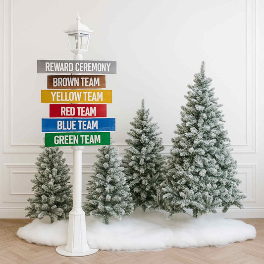 Decorative signpost with color-coded team names next to snow-covered trees indoors.