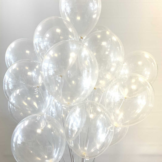 Clear balloons helium filled against a white background with silver ribbon.
