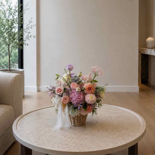 Floral arrangement on a round marble table in a living room.