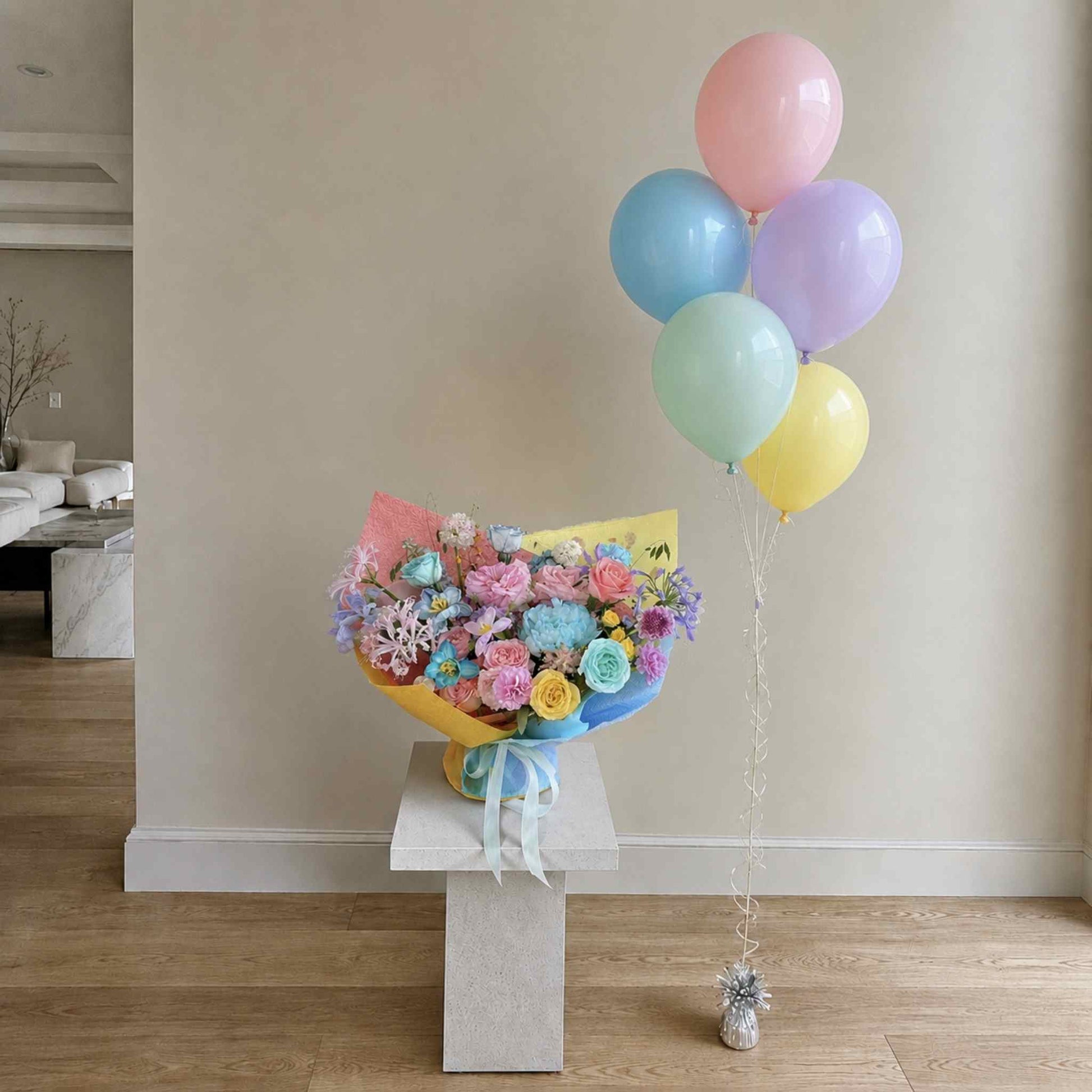 Bouquet of flowers with colorful balloons on a stand in a room.
