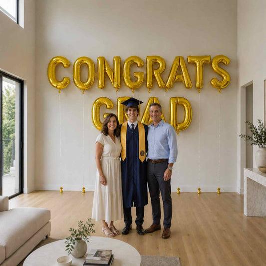 Graduate with family in front of 'CONGRATS GRAD' balloons in a modern living room.