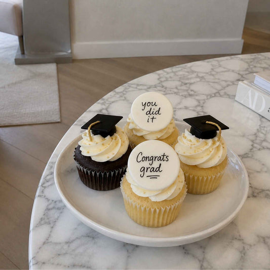 Graduation-themed cupcakes on a marble table