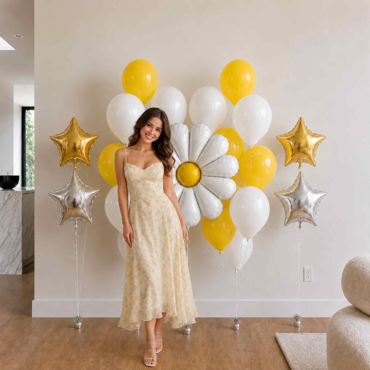 Woman in a yellow dress standing in front of decorative balloons and flowers.