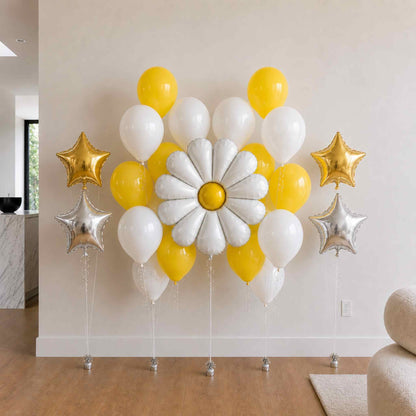 Decorative balloon arrangement with yellow, white, and gold balloons in a room setting.