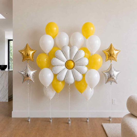 Decorative balloon arrangement with yellow, white, and gold balloons in a room setting.