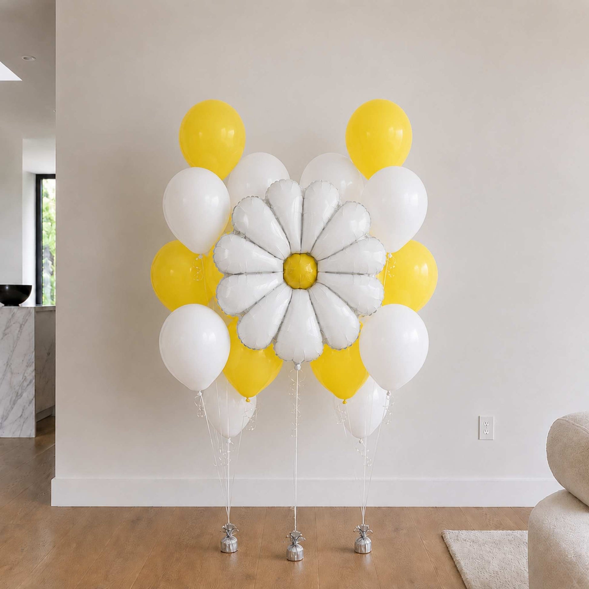 Decorative balloon arrangement with a daisy balloon in a room setting.