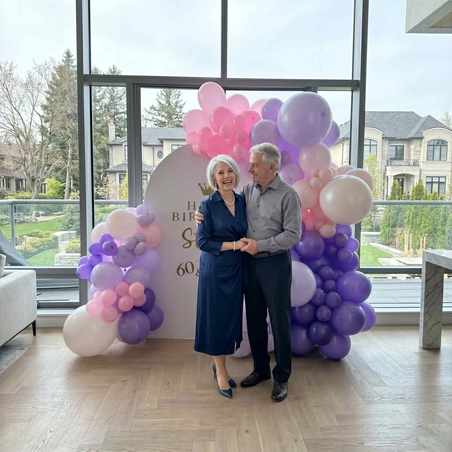 happy birthday balloon backdrop pink and purple colour. apartment setup woman and man standing infront