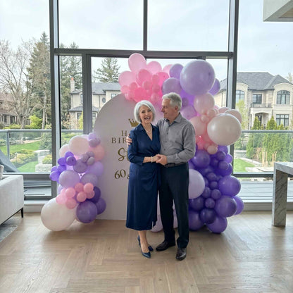 happy birthday balloon backdrop pink and purple colour. apartment setup woman and man standing infront