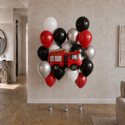 Red fire truck balloon centerpieces with black, white, and red balloons in a room.