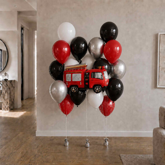 Red fire truck balloon centerpieces with black, white, and red balloons in a room.