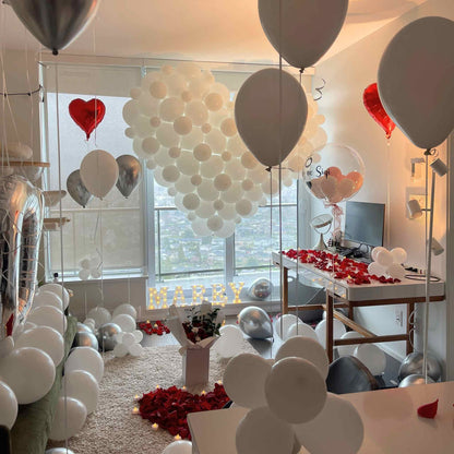 Decorated room with balloons and red heart decorations, likely for a celebration.