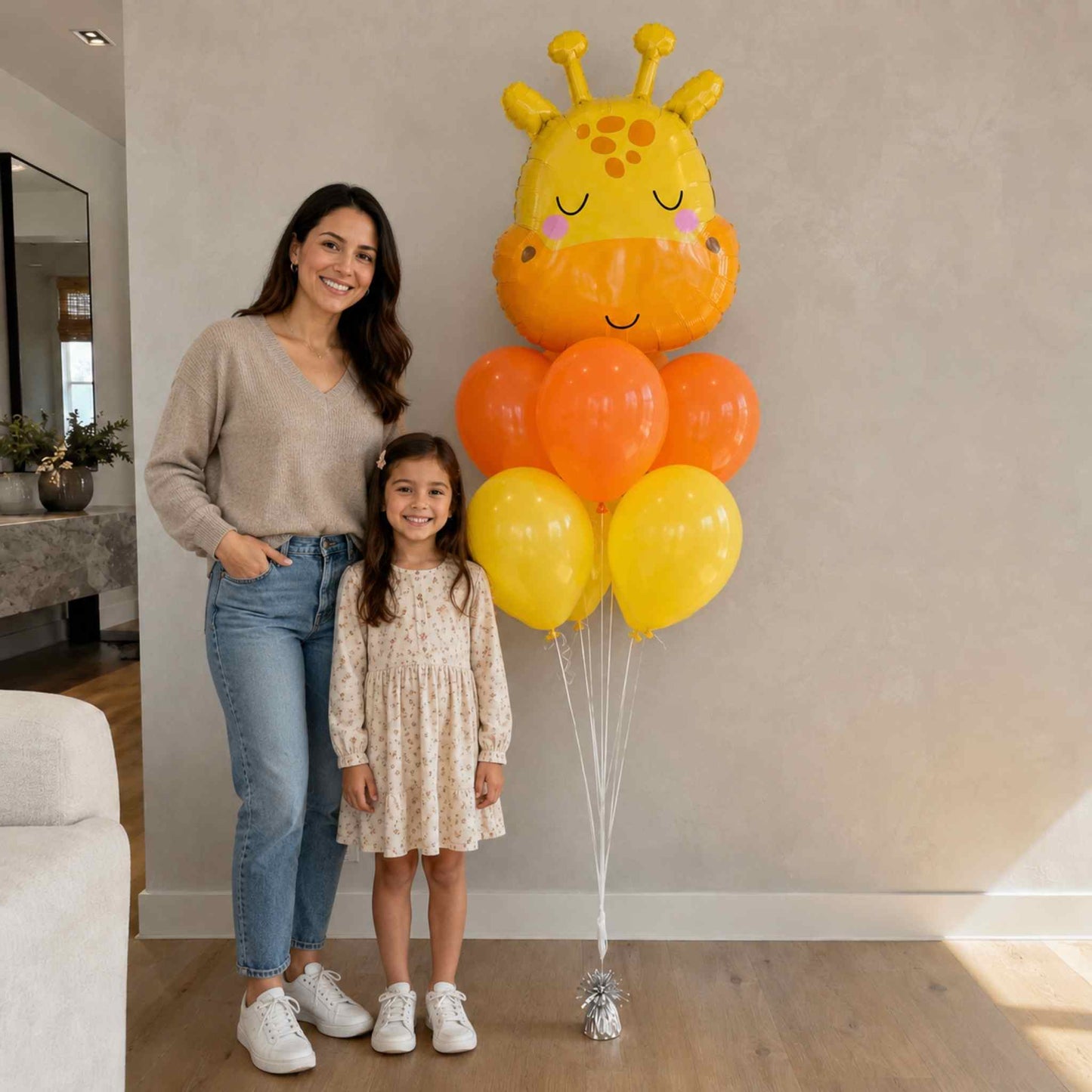 Woman and child standing next to a giraffe-shaped balloon bouquet indoors.