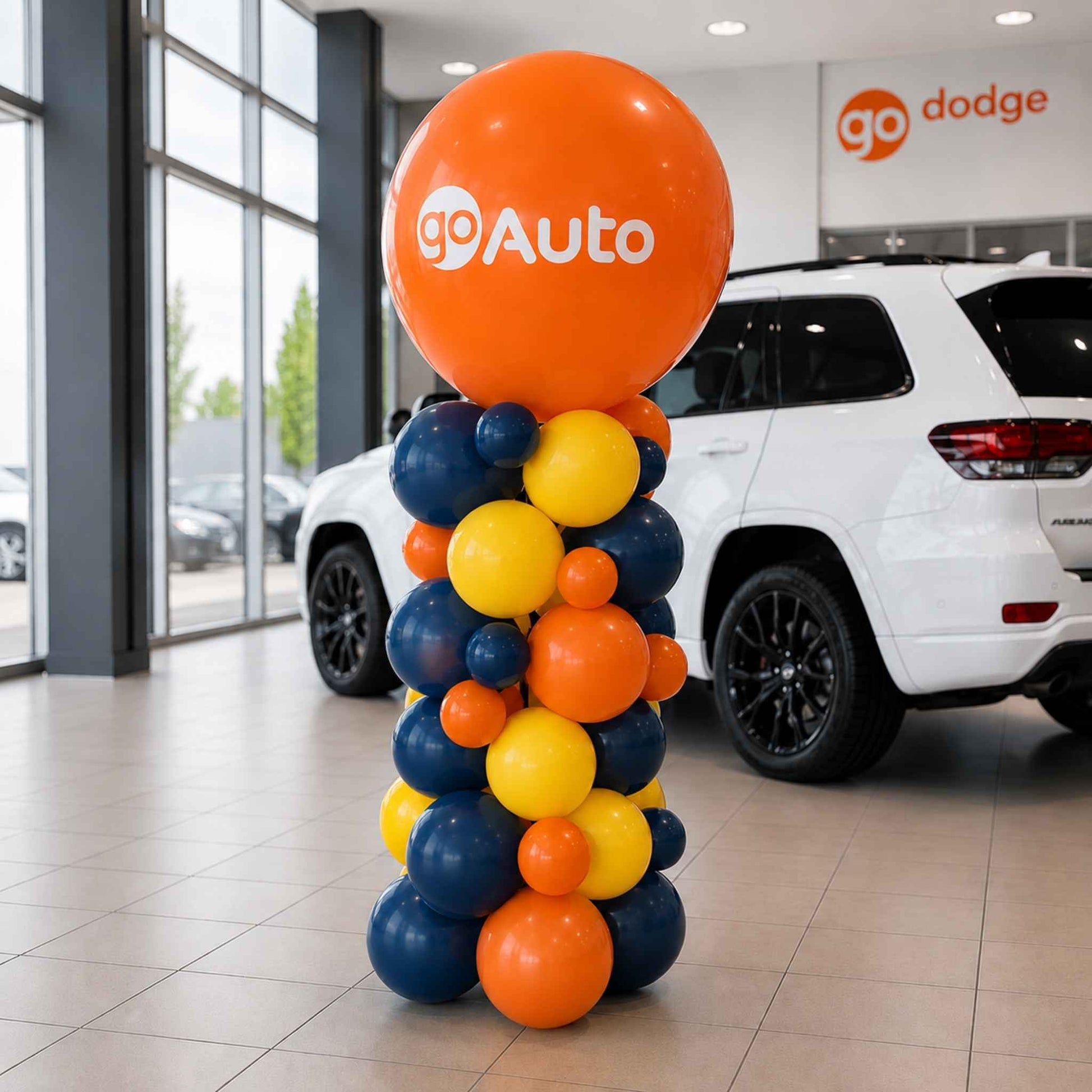 Colorful balloon column with 'goAuto' branding in a car dealership.