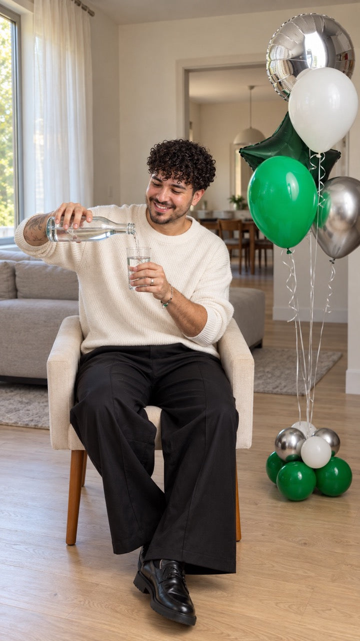 men posing with balloons pouring water in a house green and silver