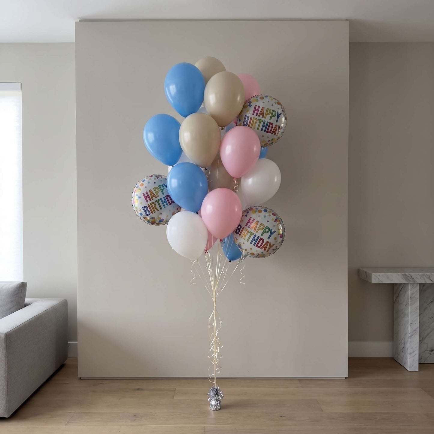 Bouquet of colorful balloons with 'Happy Birthday' on a neutral background
