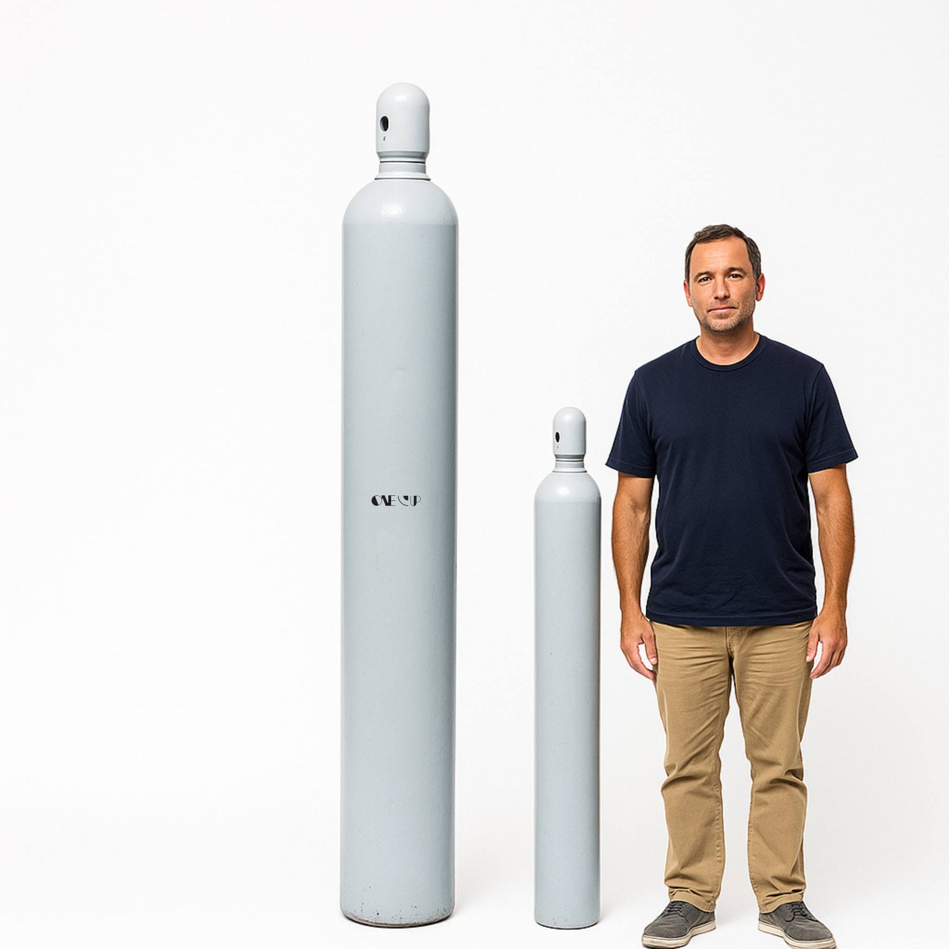 Man standing next to two large helium cylindrical objects on a white background