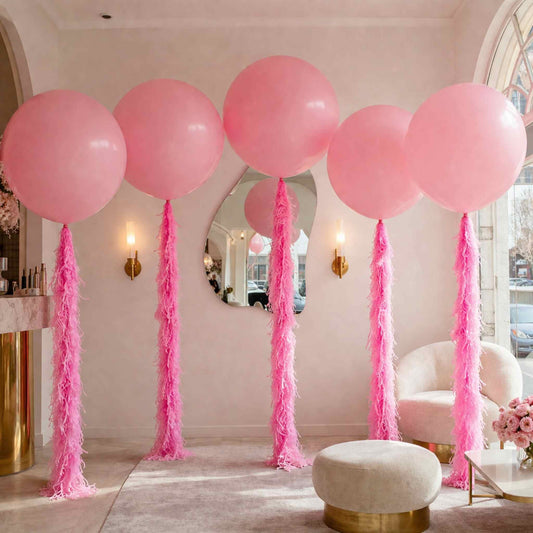 Pink balloons with tassels in a room setting
