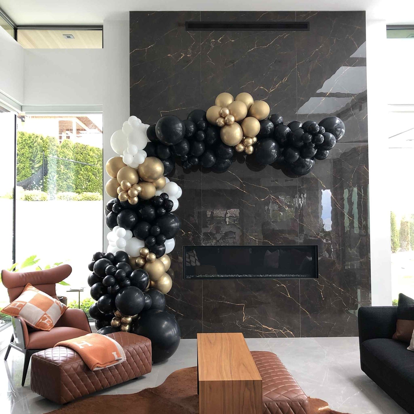 Balloon arch in a modern living room with marble fireplace
