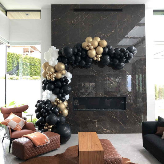Balloon arch in a modern living room with marble fireplace