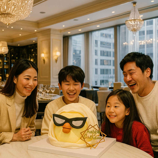 Family of four celebrating a birthday with a cake in a restaurant.