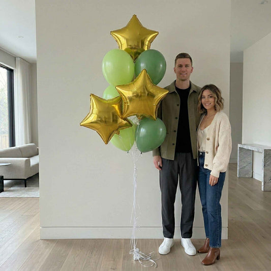 Man and woman standing indoors with green and gold balloons