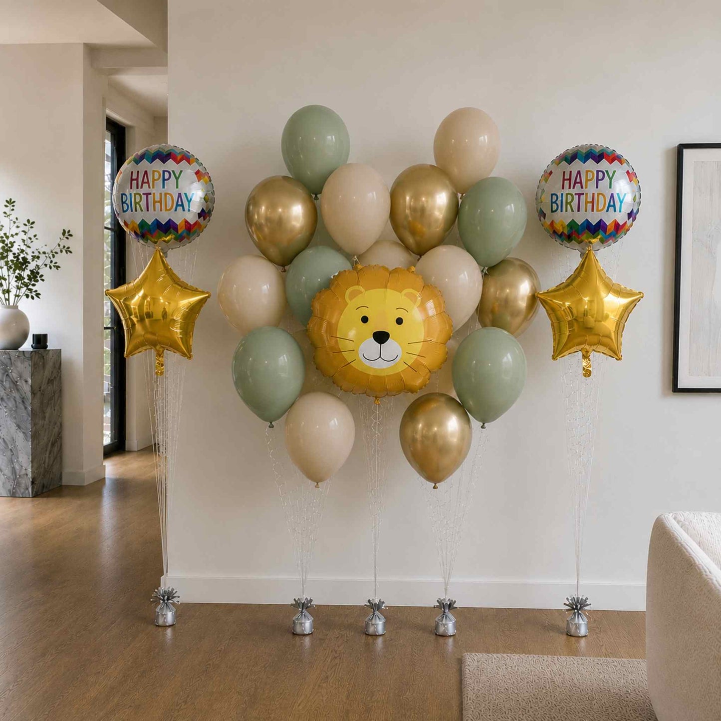 Decorative balloon arrangement with lion face balloon and 'Happy Birthday' balloons in a room setting.