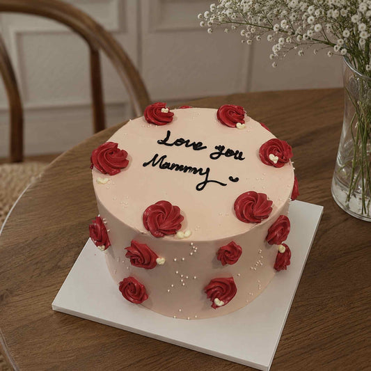Love you mommy cake staged on table with red roses and small crystals, black text eatable.  
