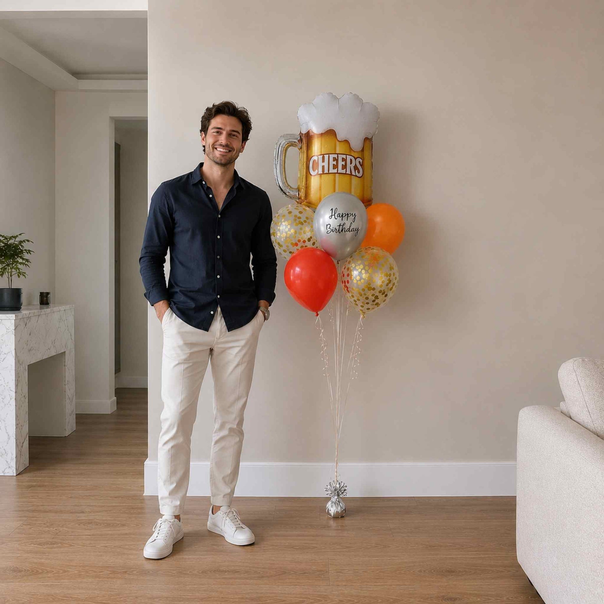 Man standing indoors with balloons including a large beer mug balloon.