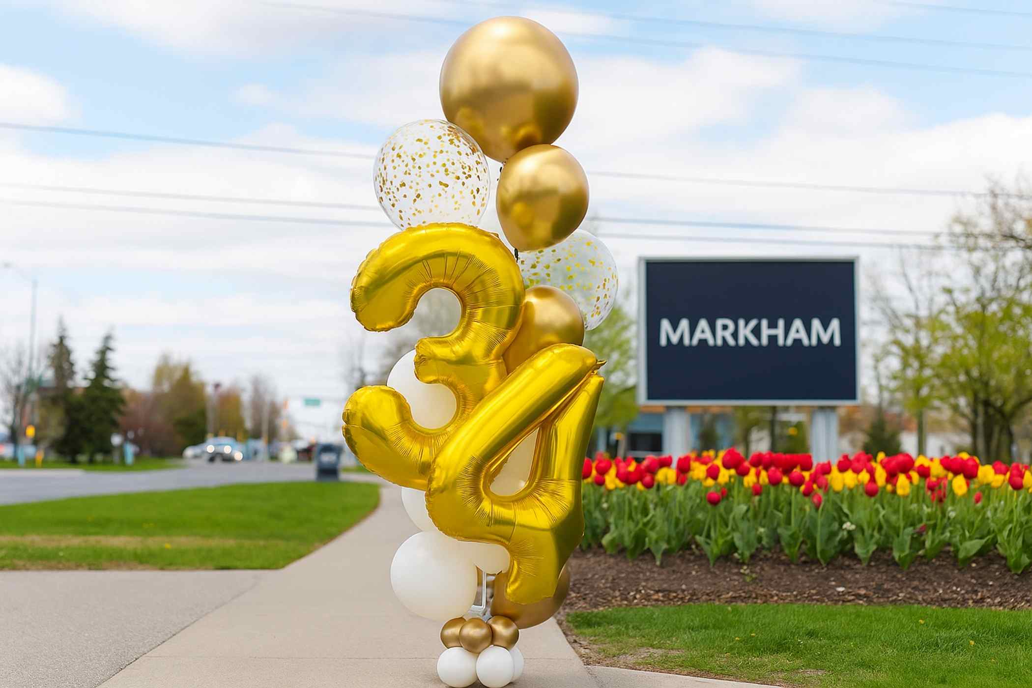 Gold balloons shaped like the number '34' with a 'Markham' sign in the background.