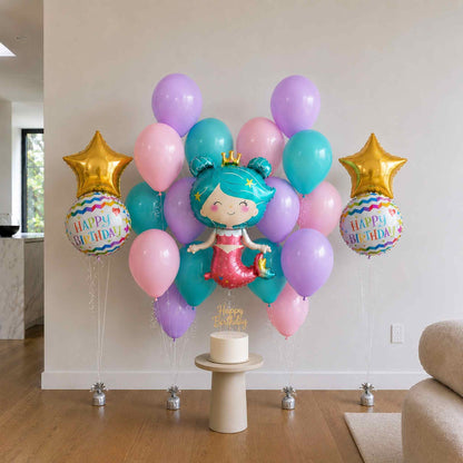 Colorful birthday balloons with a mermaid theme on a wooden floor.