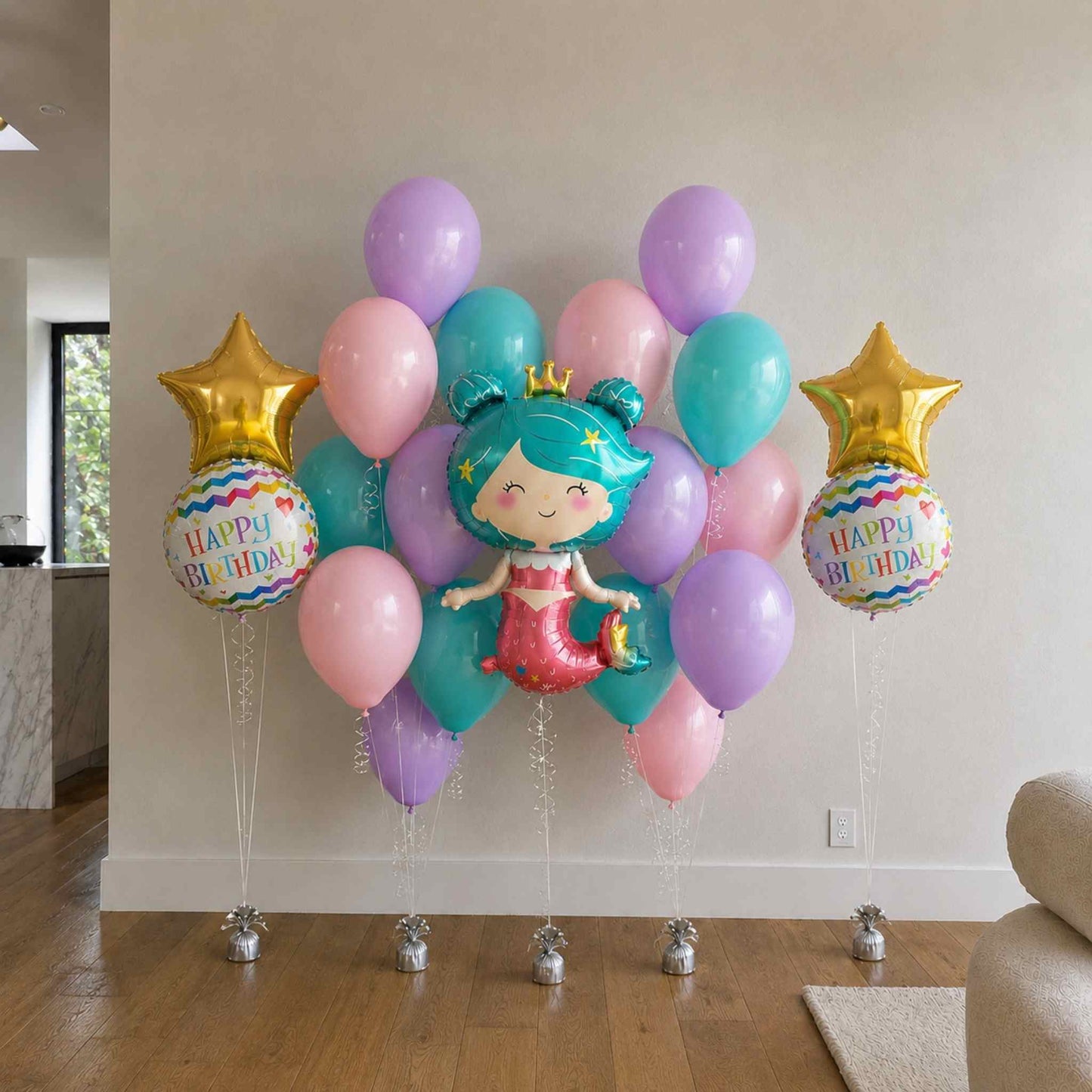 Colorful birthday balloons with a mermaid design and 'Happy Birthday' text in a living room setting.