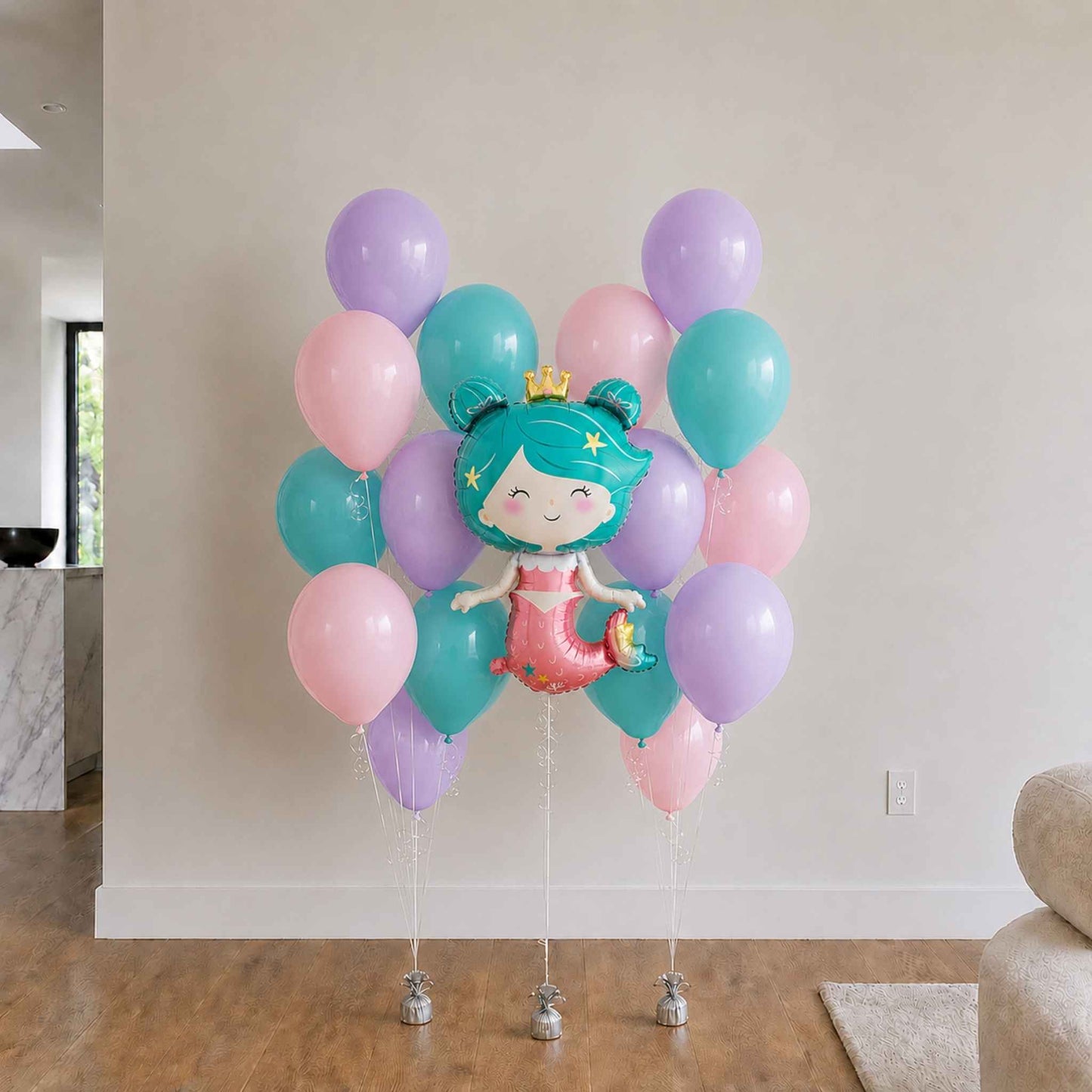 Mermaid-themed balloon bouquet with pastel colors in a living room setting.