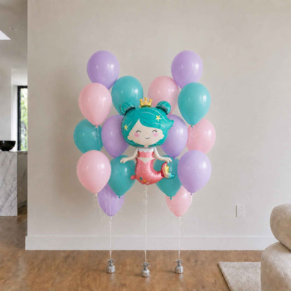 Mermaid-themed balloon bouquet with pastel colors in a living room setting.