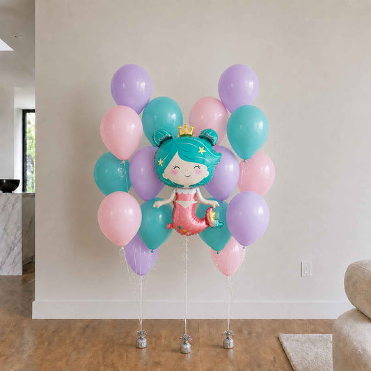 Mermaid-themed balloon bouquet with pastel colors in a living room setting.