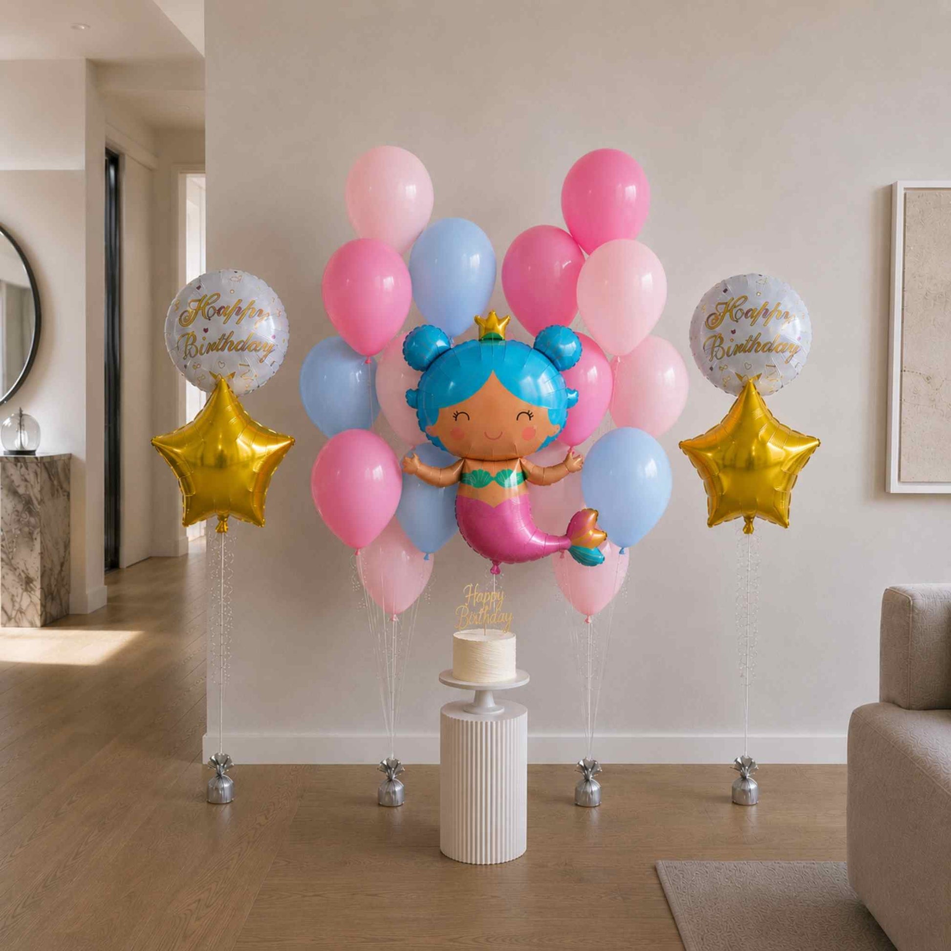 Colorful balloon arrangement with a mermaid balloon and 'Happy Birthday' balloons in a room.