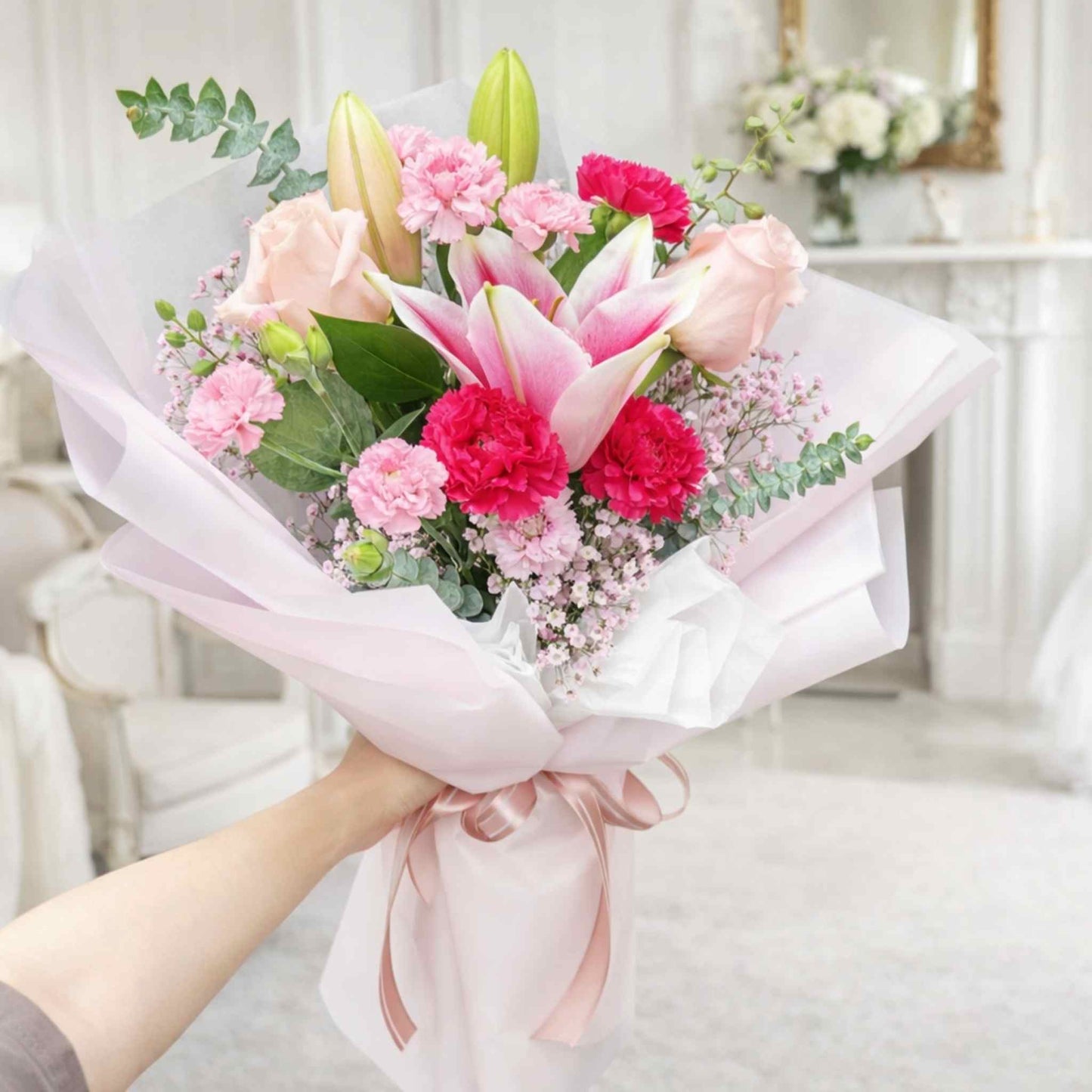Bouquet of flowers held by a person in a softly blurred indoor setting