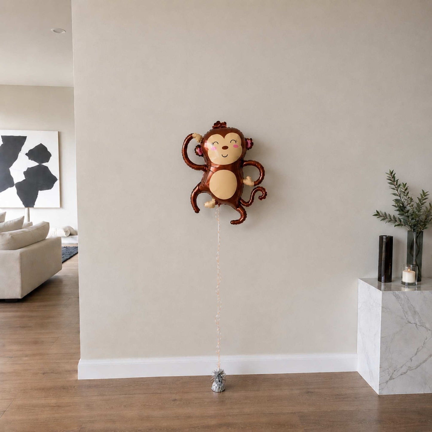 Monkey-shaped balloon against a beige wall in a living room setting