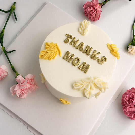 thanks mom cake white with pink on a table
