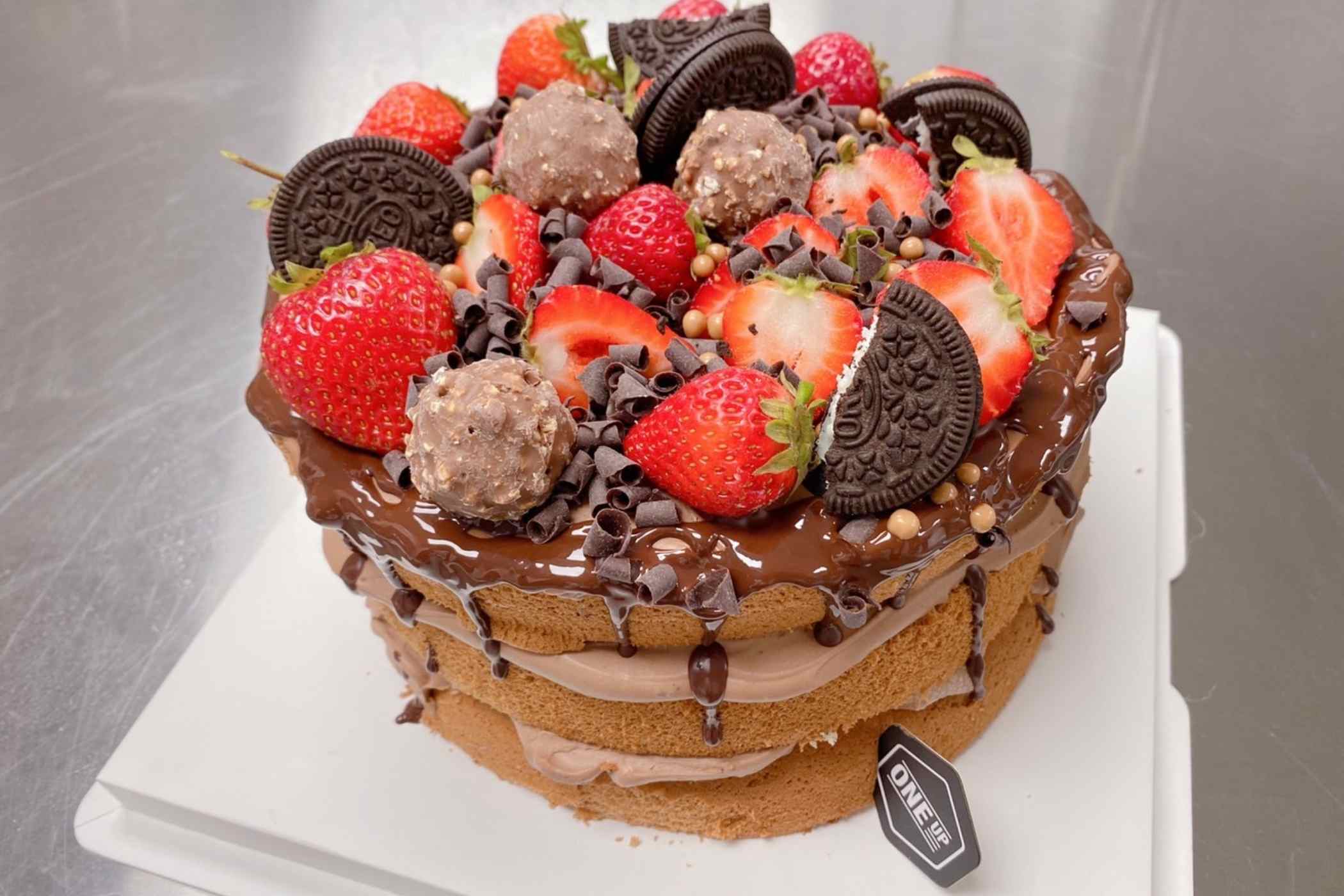 Chocolate cake with strawberries and Oreo cookies on a white surface