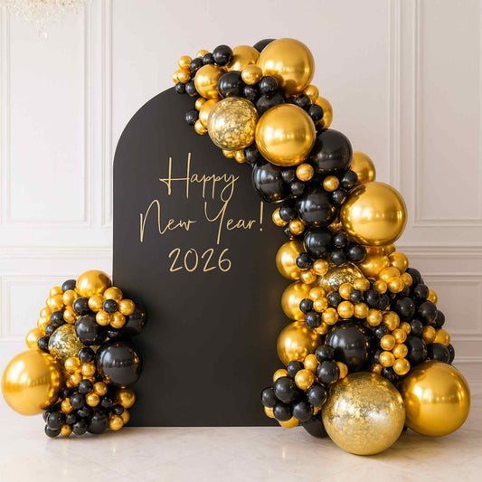 Decorative arch made of gold and black balloons with 'Happy New Year! 2026' sign on a white background
