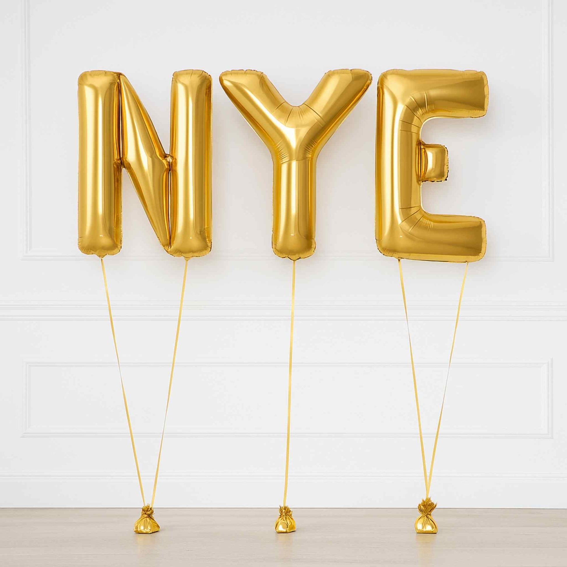 Gold 'NYE' balloons on a white background