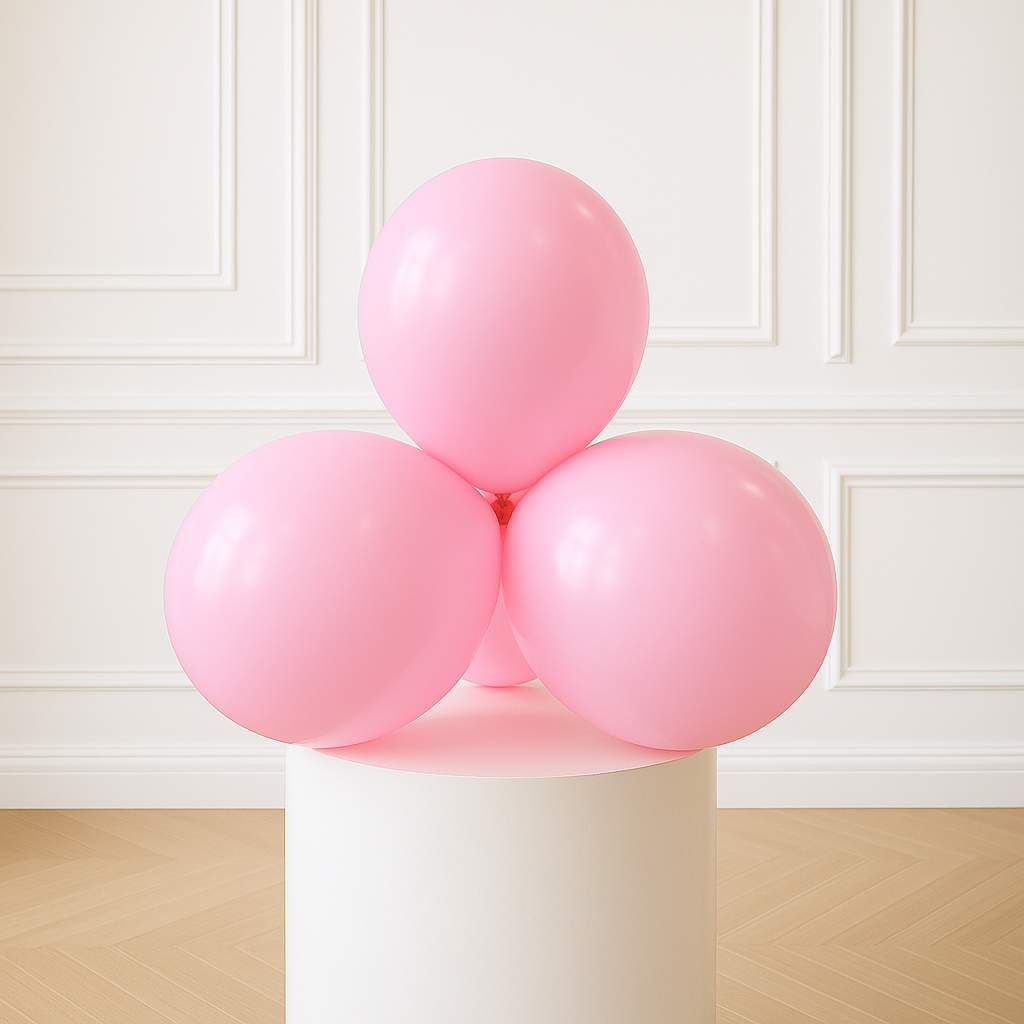 Pink balloons on a white pedestal against a white paneled wall.