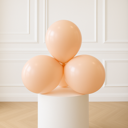 Three peach-colored balloons on a white pedestal against a white paneled wall.