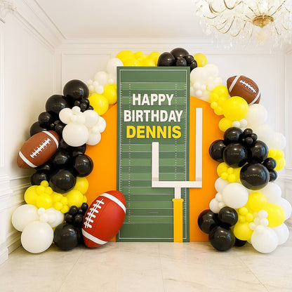 Decorative balloon arch with football theme and personalized birthday message.