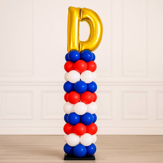 Balloon sculpture with gold letter 'D' on top against a light background