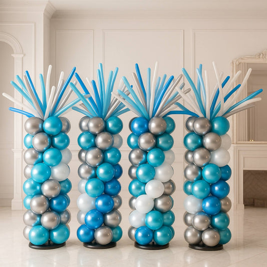 Four tall balloon columns in blue, silver, and white on a white floor with a light-colored wall background.