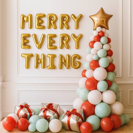 Decorative setup with 'Merry Everything' balloons, a balloon Christmas tree, and gift boxes.