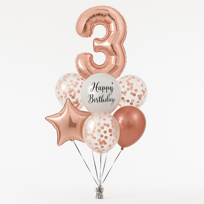 A bouquet of rose gold colored balloons including a large number 3, a 'Happy Birthday' script balloon, a rose gold star-shaped balloon, and several confetti balloons.
