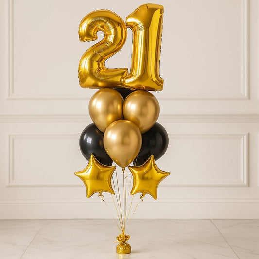 Gold, black, and star-shaped balloons with a number '21' against a white paneled wall.