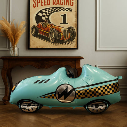Turquoise car-shaped balloon in a room with a vintage racing poster on the wall.